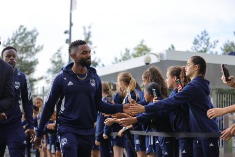 Les filles de l'école de football accueillent les joueurs au Stade